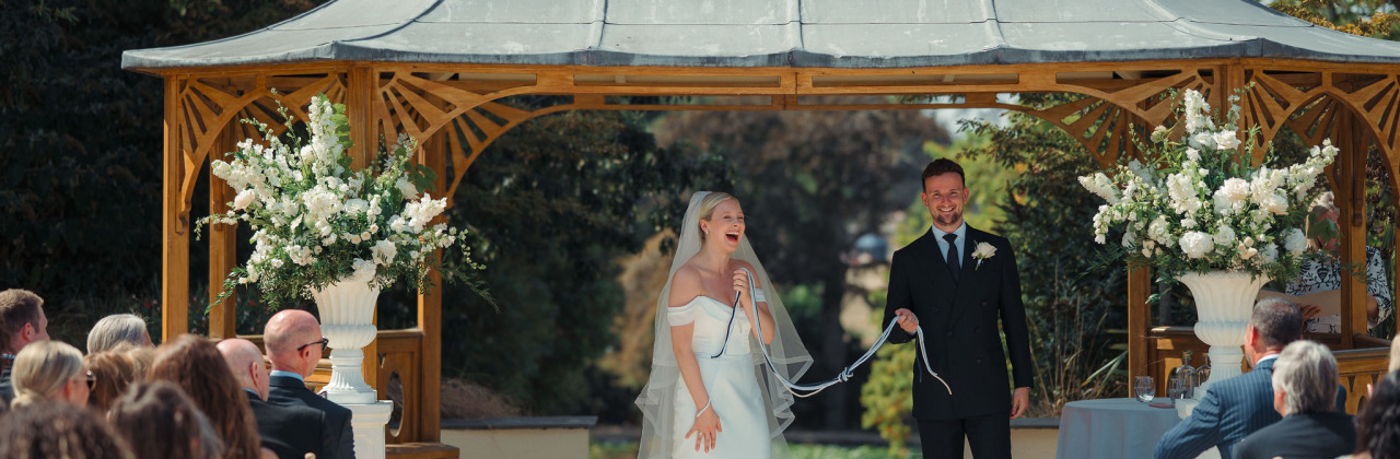 The bride laughs in a beautiful moments following the end of the handfasting ceremony with Sam White Celebrant at Clevedon Hall.
