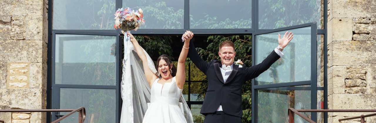 A photo of a couple making an entrance after wedding ceremony at Old Gore Barn with Sam White Celebrant.