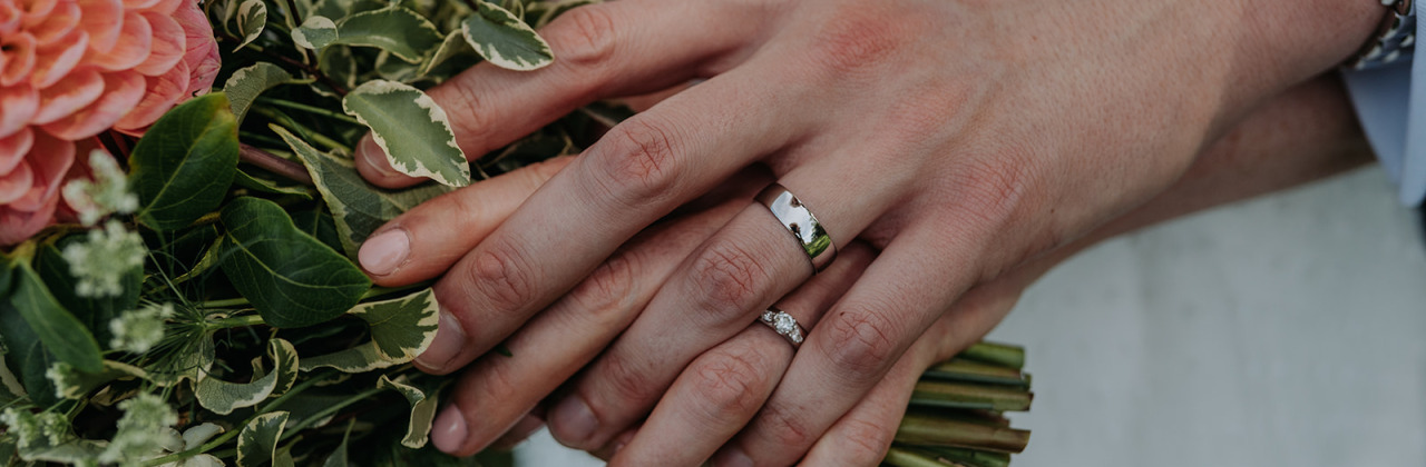 A photo of a couple with their wedding rings and the bouquet at Noah's Pond in Somerset.