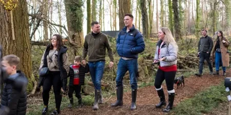 A group of people walking in a woodland
