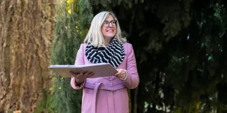 A celebrant with her folder smiling