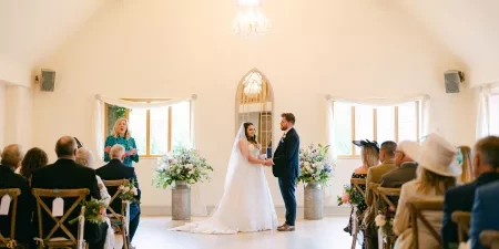 A couple in a barn being married with a celebrant