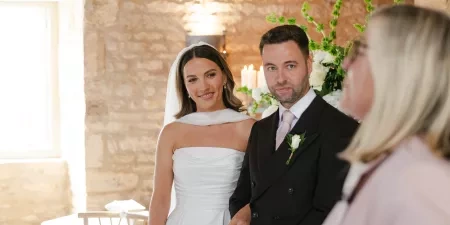 A couple standing with their celebrant in a horse shoe formation during their wedding ceremony at Ivy Lodge in the Cotswolds.