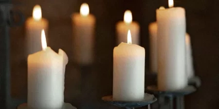 A close-up of some modern and elegant looking white candles in the wedding ceremony room at Ivy Lodge in Circencester.