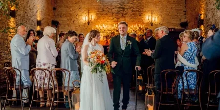 A photo of the couple walking back down the aisle after a wedding ceremony with Sam White Celebrant at Cripps Barn.