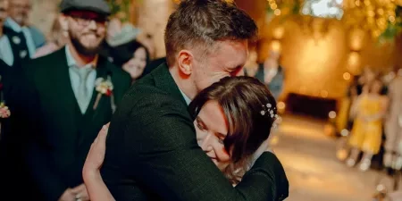 A photo of a bride and groom hugging each other after the bride's entrance.