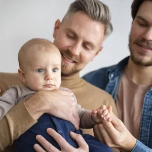 Two men holding a baby
