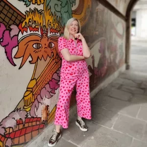A woman stood in a archway with graffiti in the background