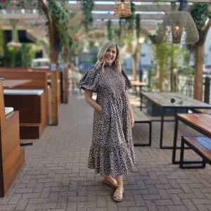 A woman stood with her hand in her pocket smiling