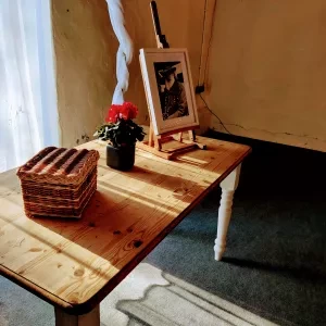A table with a photograph of a man, flowers and a basket